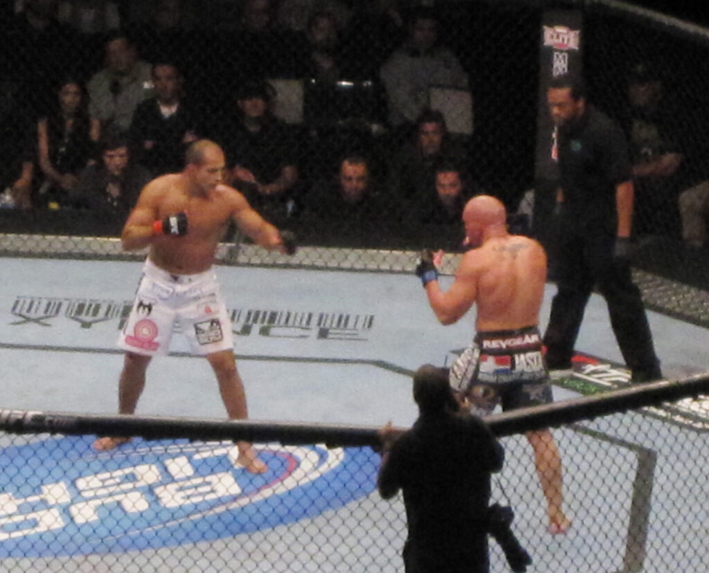 Two mixed martial arts fighters facing off inside a cage, illustrative photo