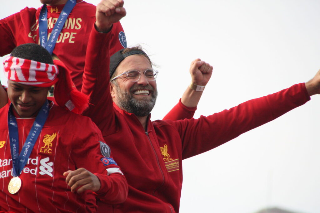 Jurgen Klopp smiling and waving during Liverpool's 2019 Champions League trophy parade