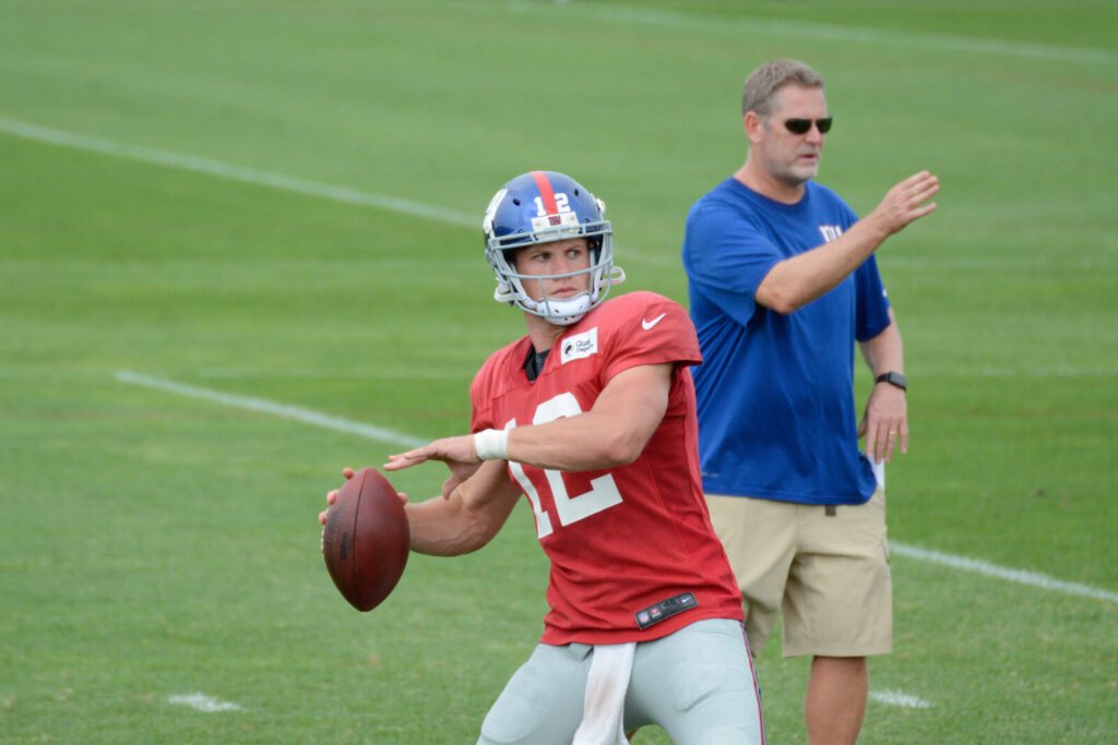 A New York Giants player in pads during an outdoor training camp practice session.