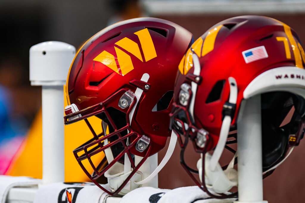 Football helmets on the sideline rail during an NFL game