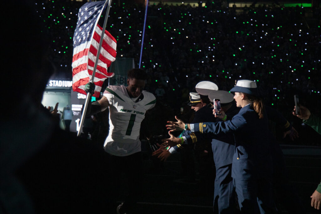 New York Jets cornerback Sauce Gardner runs onto the field at MetLife Stadium before an NFL game.