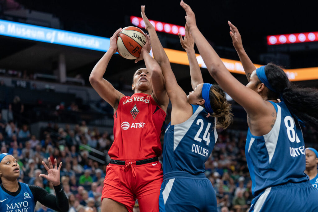 A'ja Wilson drives to the basket and shoots while guarded by defenders during a WNBA game