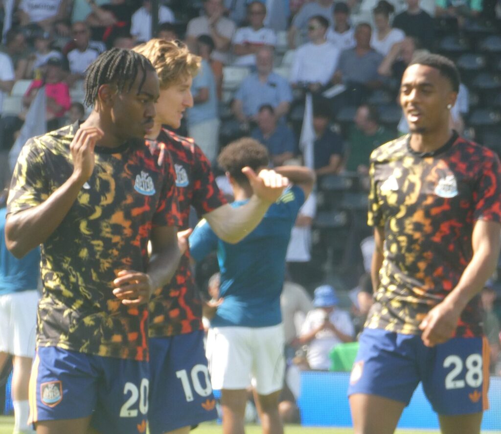 Anthony Gordon warming up alongside Anthony Elanga and Joe Willock before a Fulham vs Newcastle United match, in Newcastle kit
