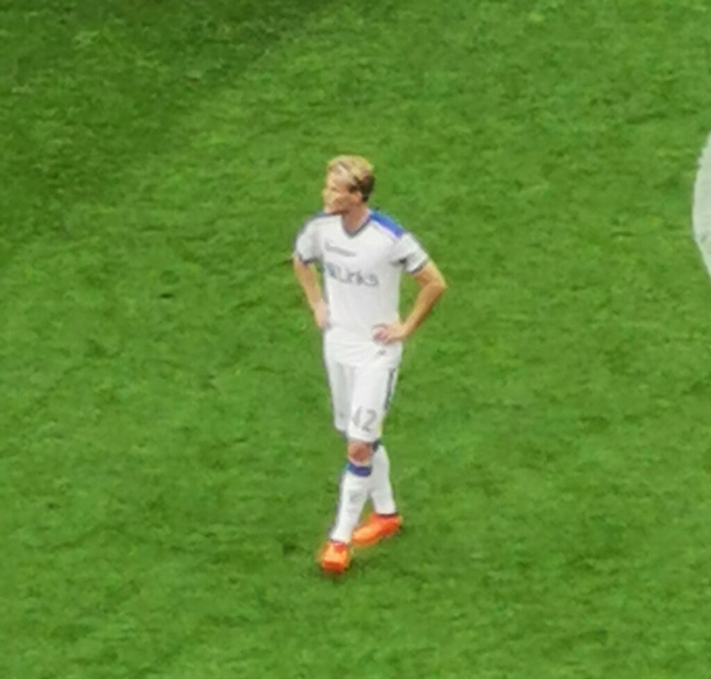Morten Hjulmand in white Lecce kit standing on the pitch during a 2023 Serie A match against Milan