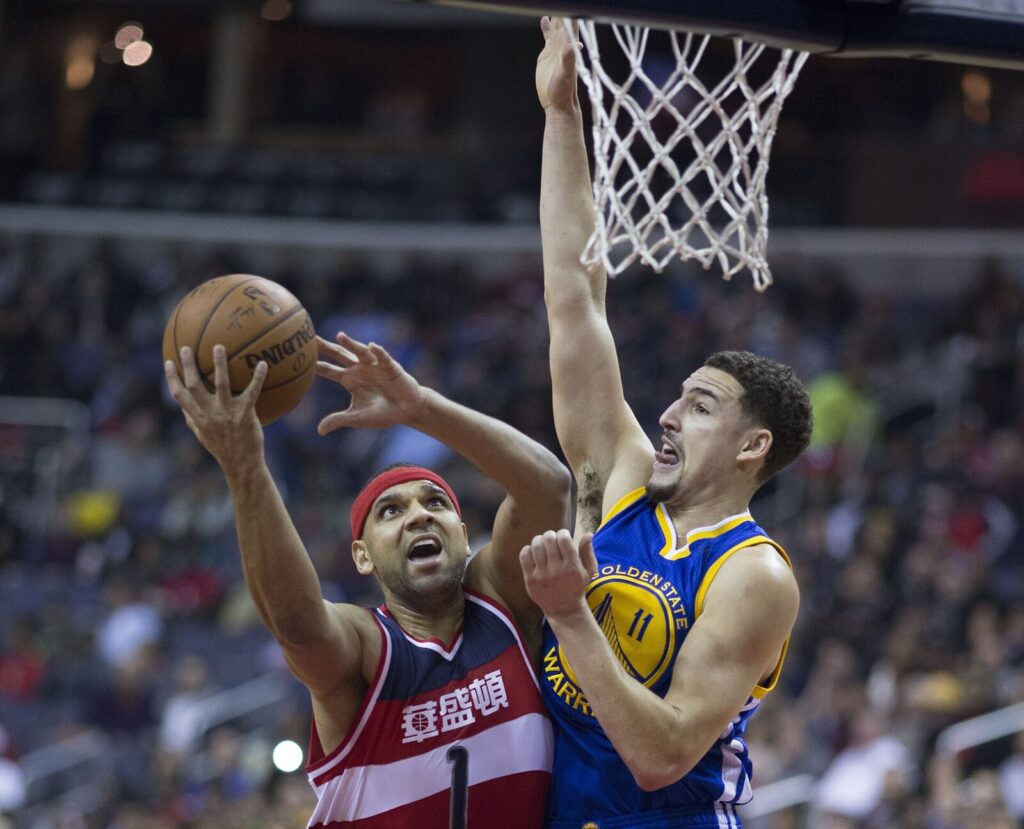 Klay Thompson in a Golden State Warriors jersey driving to the basket during a 2016 game against the Washington Wizards (Foto de arquivo: Klay Thompson pelo Golden State Warriors, 2016.)