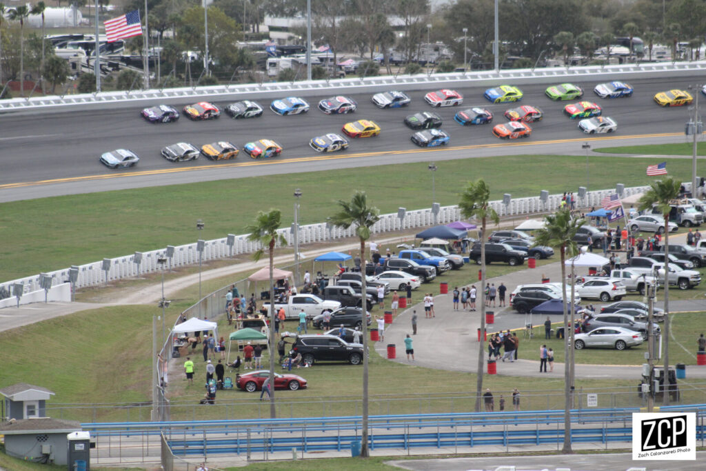 NASCAR Cup Series cars racing side by side at the start of a race at Daytona International Speedway.