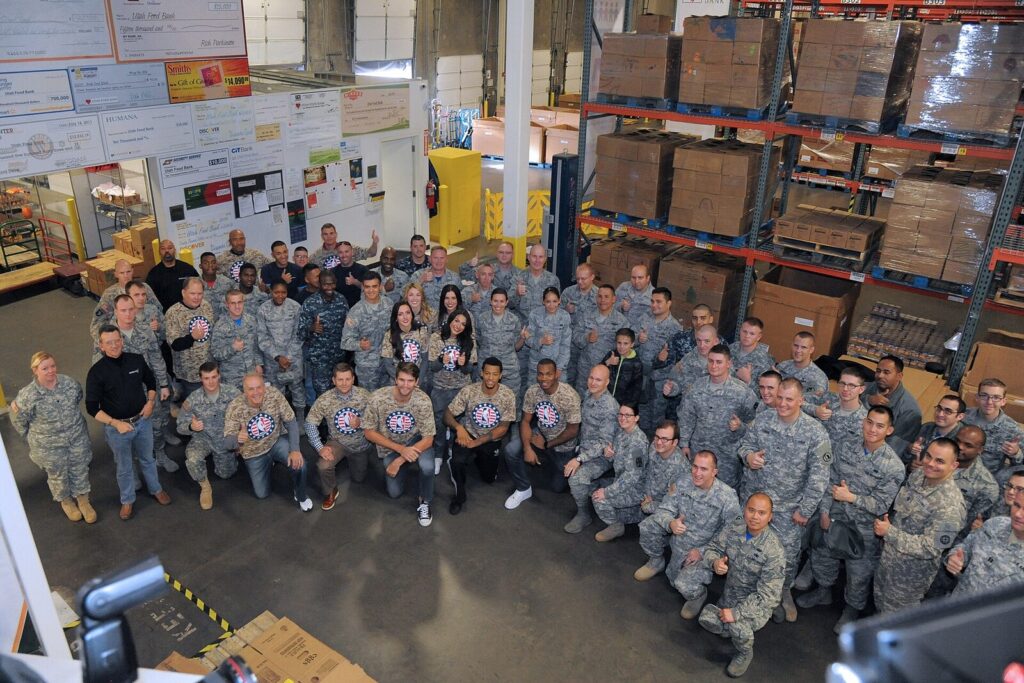 NBA players and community volunteers pose together at a 2015 Veterans Day service event (Foto de arquivo: evento comunitário 'Commitment to Service' da NBA com o Utah Jazz, novembro de 2015 (imagem não relacionada a um buyout específico).)