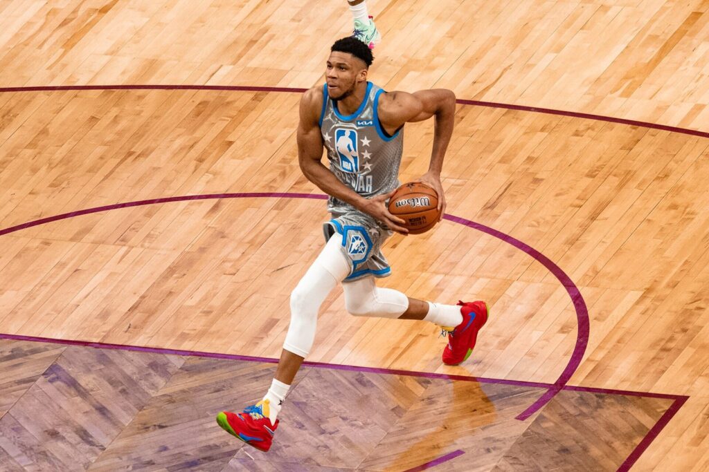 Giannis Antetokounmpo dribbling the ball in an NBA All-Star uniform (Foto de arquivo: Giannis Antetokounmpo em 2022, jogador citado no ranking de contratos.)