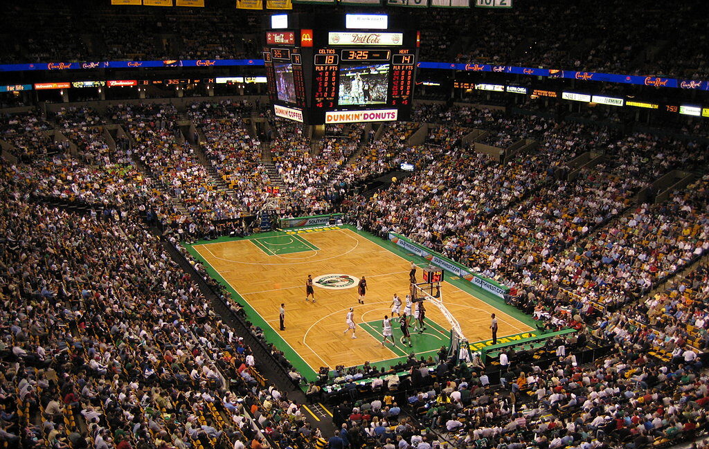 Wide elevated shot of a packed NBA arena mid-game, court and scoreboard visible (File photo: generic NBA game action, 2006.)
