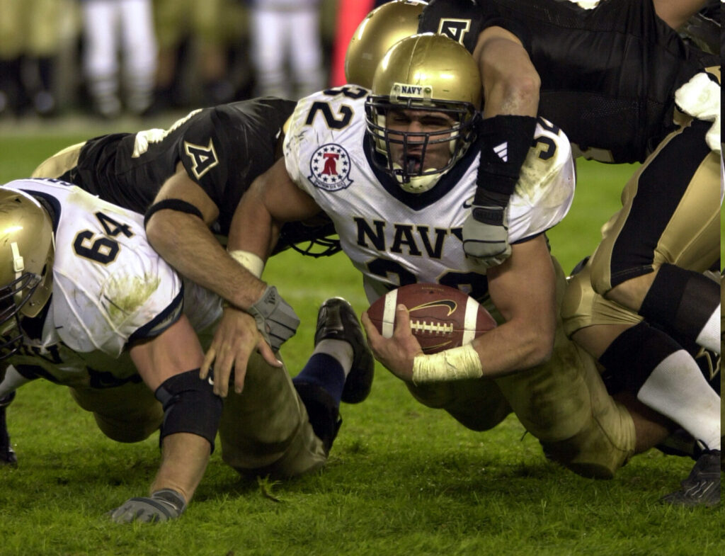 American football player tackled during a game, generic action shot (Foto de arquivo: jogo genérico de futebol americano (Army-Navy, 2003), ilustrativo do texto.)