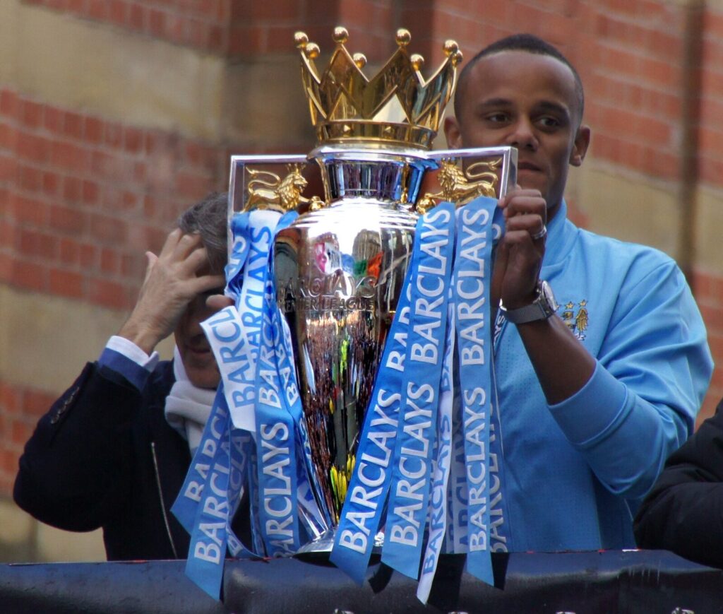Vincent Kompany holds up the Premier League trophy during a 2012 title celebration (File photo: Premier League trophy celebration, 2012, not tied to the 2026 transfer deals discussed.) (File photo: Premier League trophy celebration, 2012, not tied to the 2026 transfer deals discussed.)