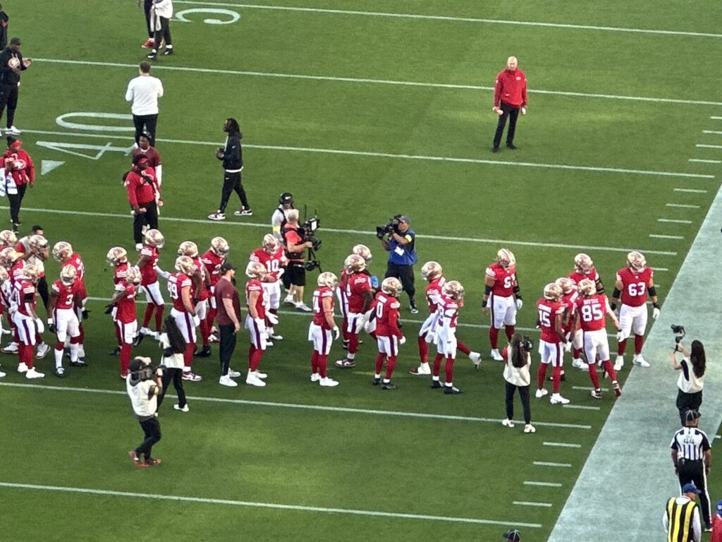 San Francisco 49ers players huddle on the field at Levi's Stadium during a game