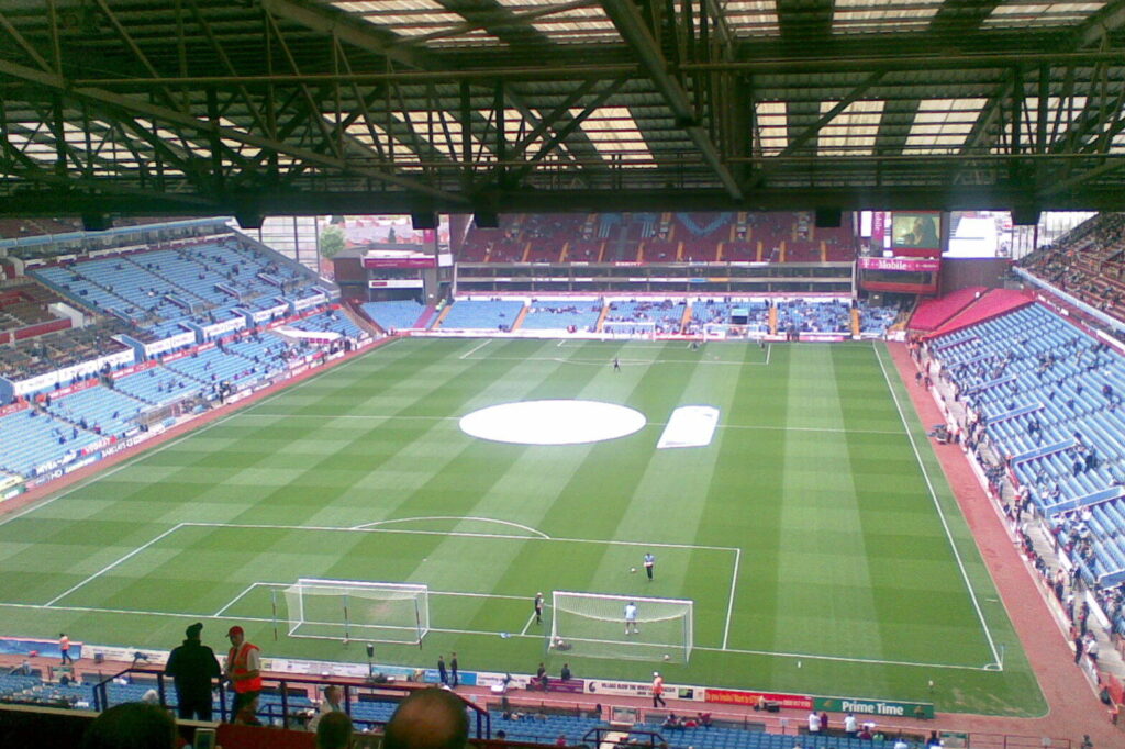 Elevated interior view of Villa Park stadium from the Holte End, showing the pitch, stands and goalposts with sparse crowd before kickoff. (File photo: Villa Park stadium, 2007.)